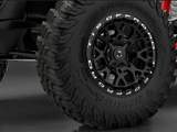 A close up photo of the TIS UT1 tire on a red off road vehicle in a showroom. 