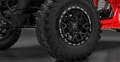 A close up photo of the TIS UT1 tire on a red off road vehicle in a showroom. 