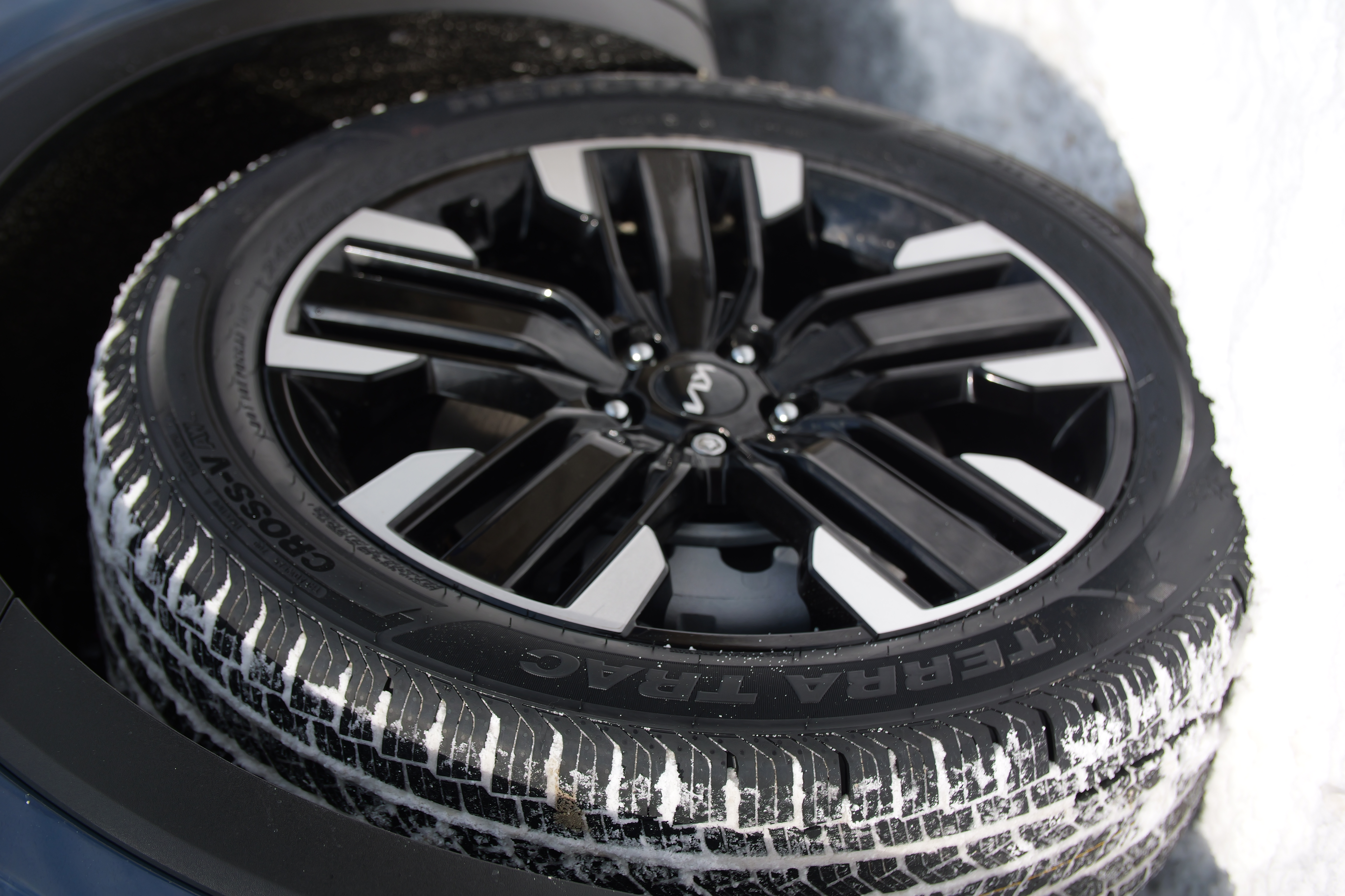 A close-up of the Hercules Tires Terra Trac Cross-V AW with its tread filled with snow from driving in snowy conditions.