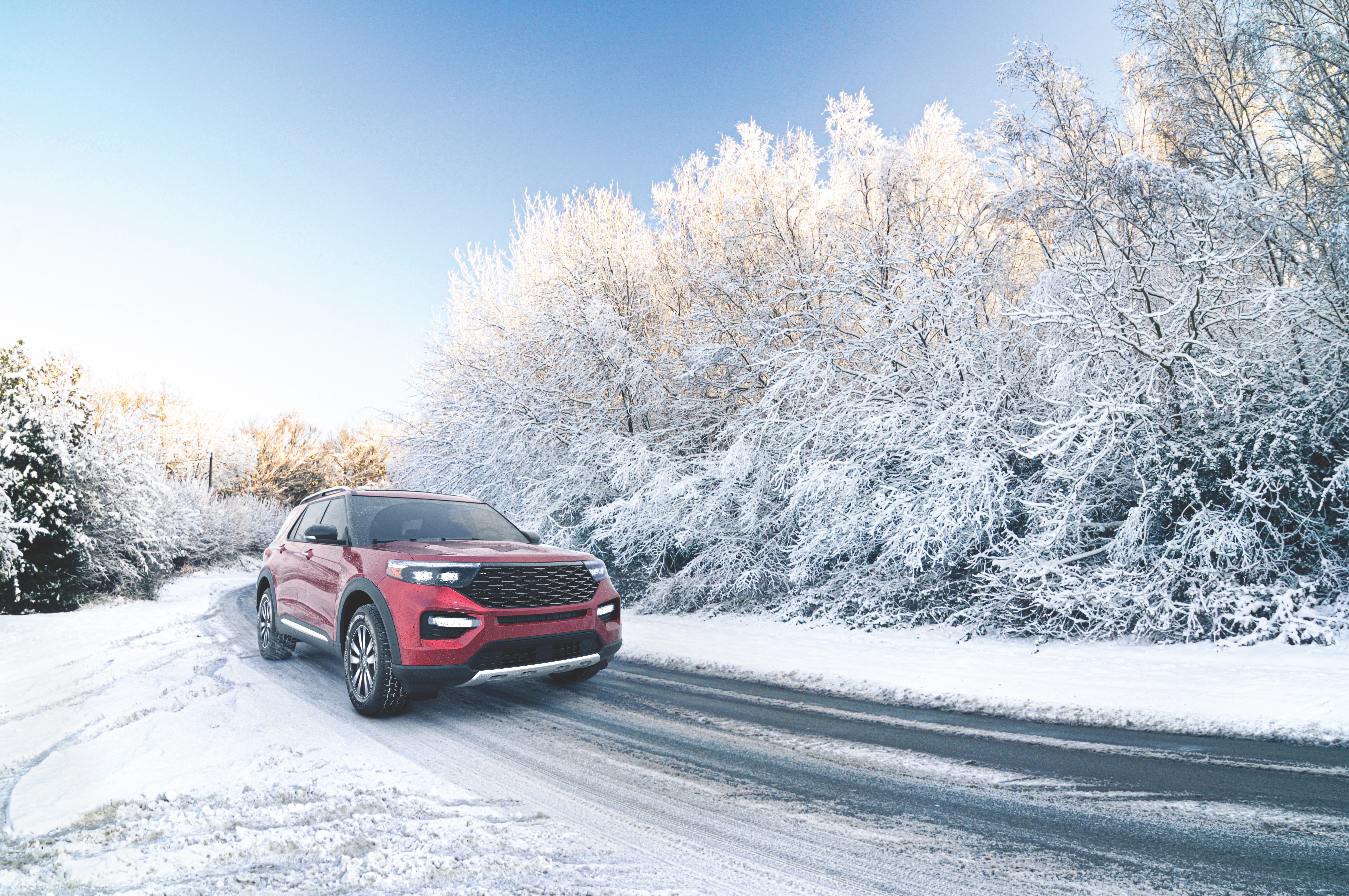 A red car driving on a snowy road outfitted in Hercules AVALANCHE® XUV tires.